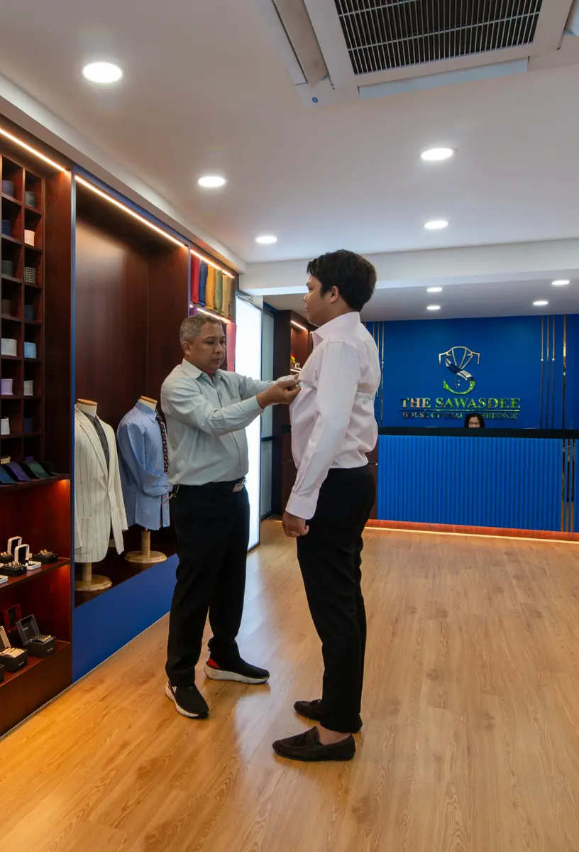 Sawasdee tailor fitting a shirt on a customer